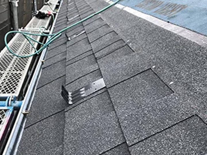 軒先から葺いていきます。<br />
専用の釘とセメントで屋根材を固定しますので風に弱いということはありません。